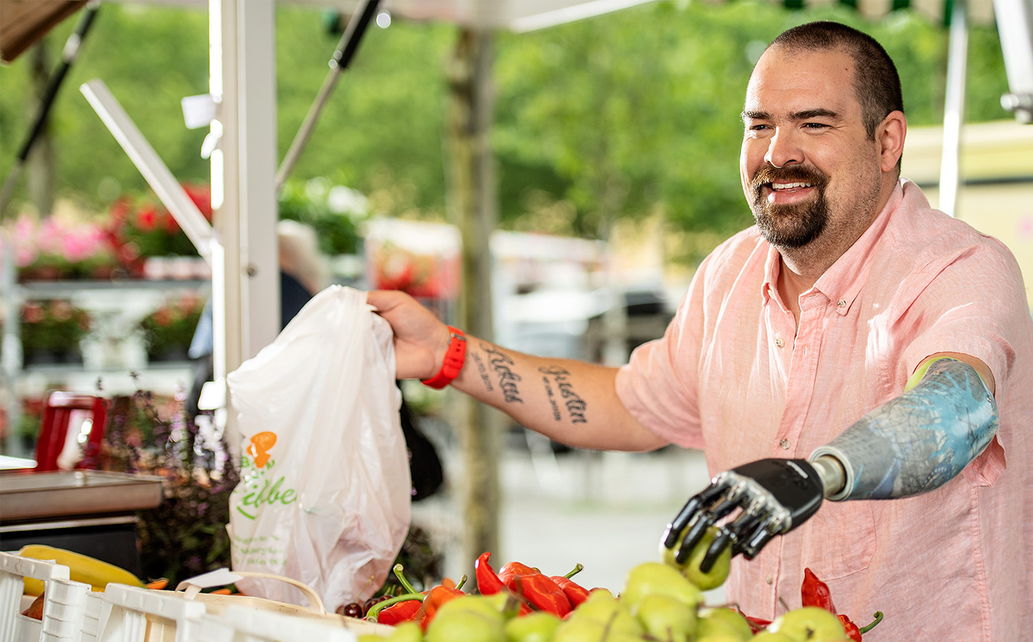 Foto Mann mit Armprothese beim Einkaufen